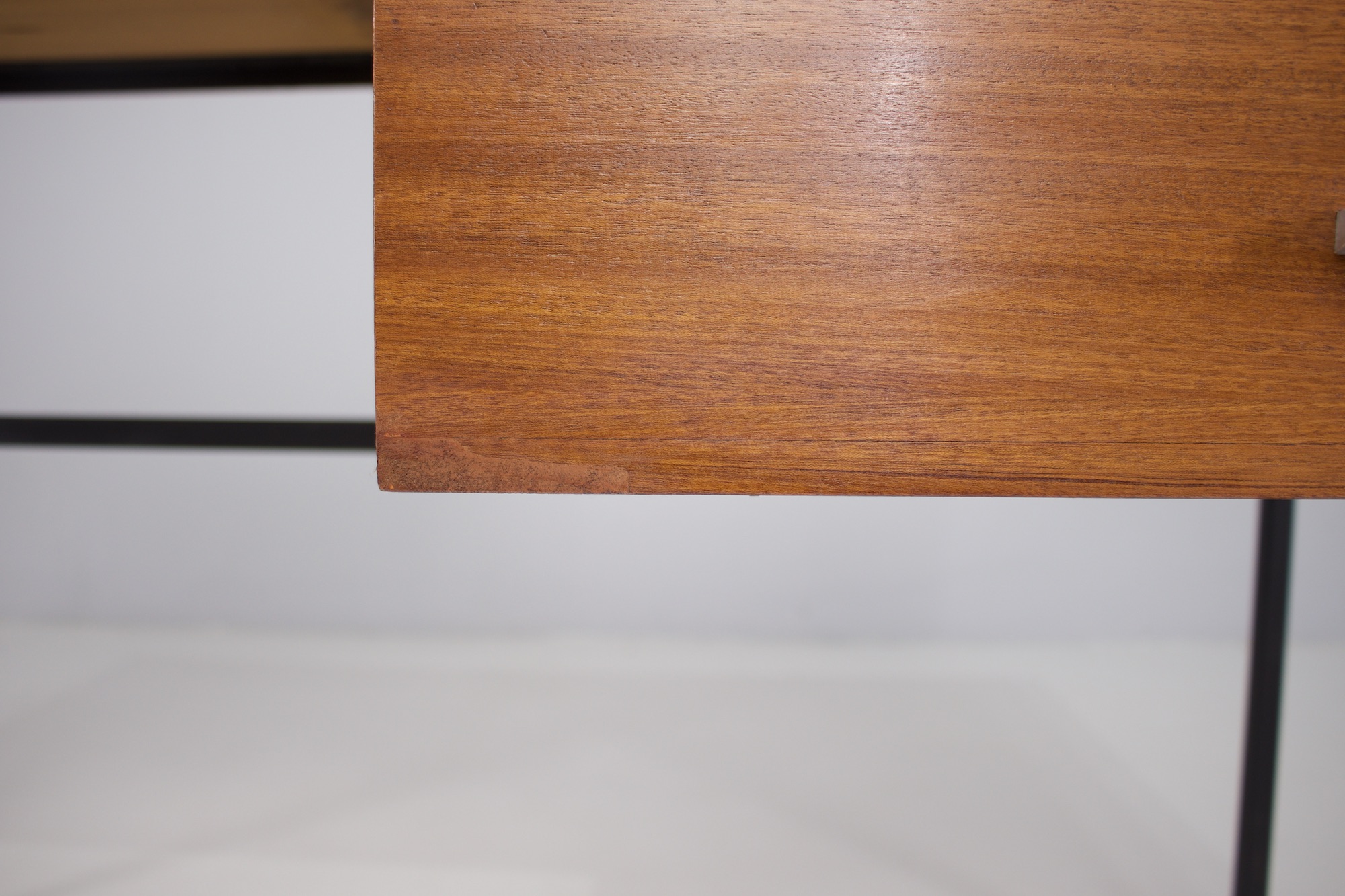 Détail de l'usure du placage sur un panneau de bois.