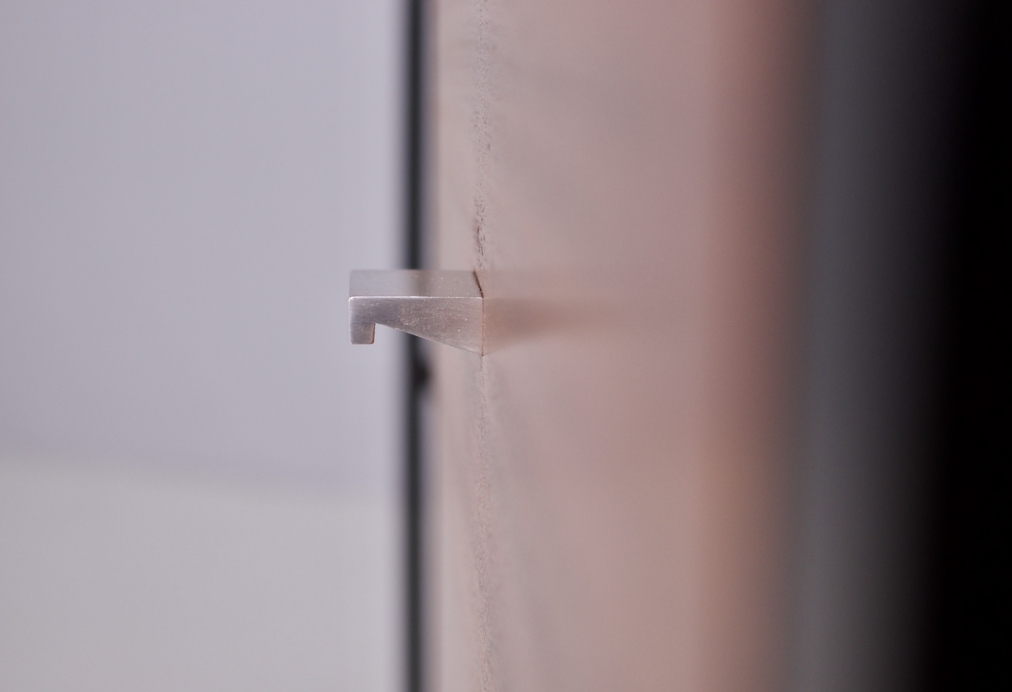 Un bouton de tiroir en aluminium vu de profil.