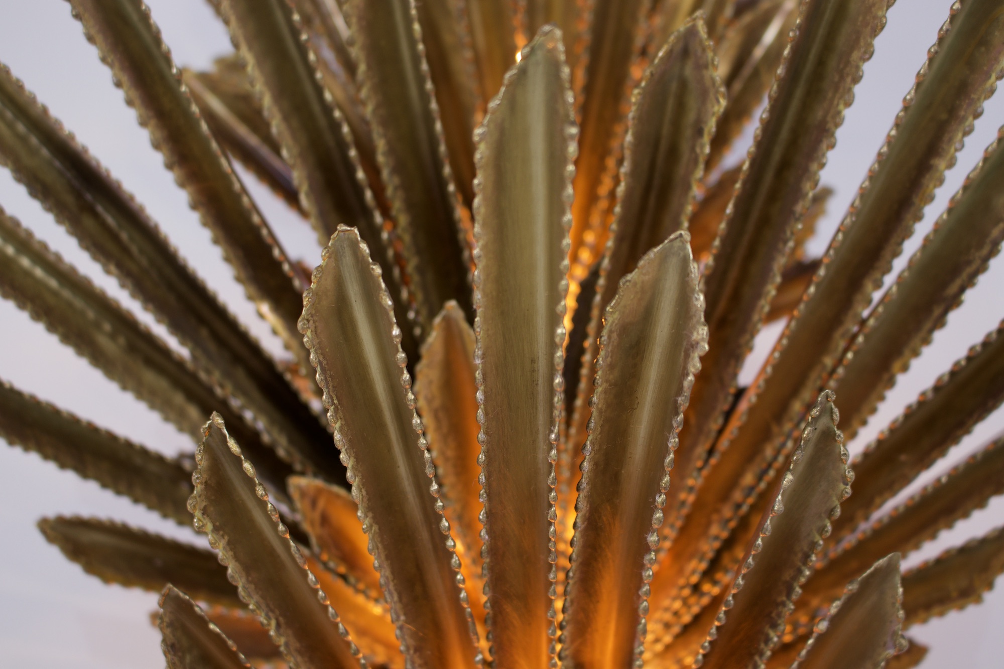 Deux appliques Maison Jansen en laiton par Christian echoueyeres, gros plan au coeur des finitions de laiton, allumée.