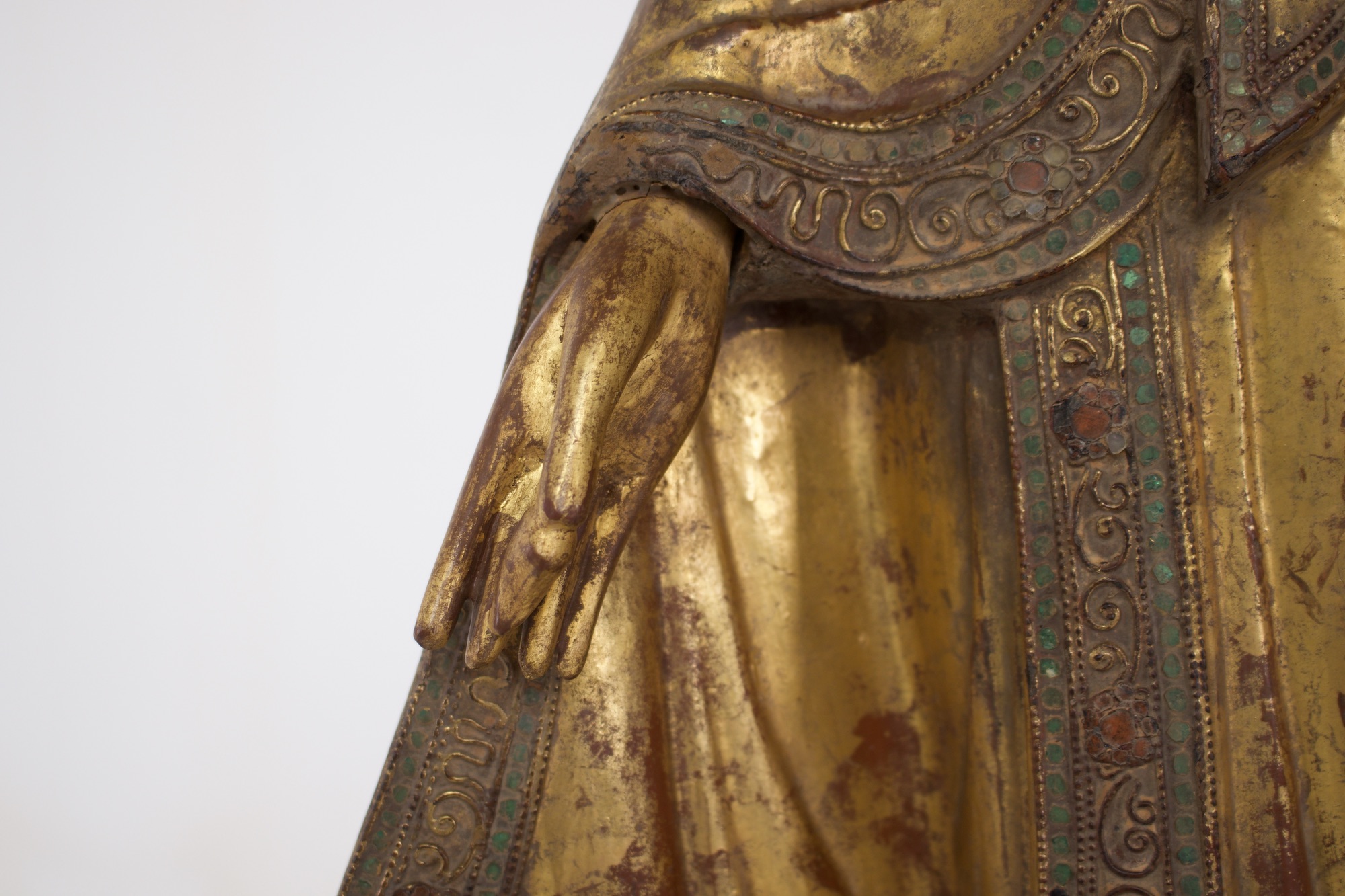 Statue ancienne de bouddha birman, détaill de la main avec le fruit du myrobolan