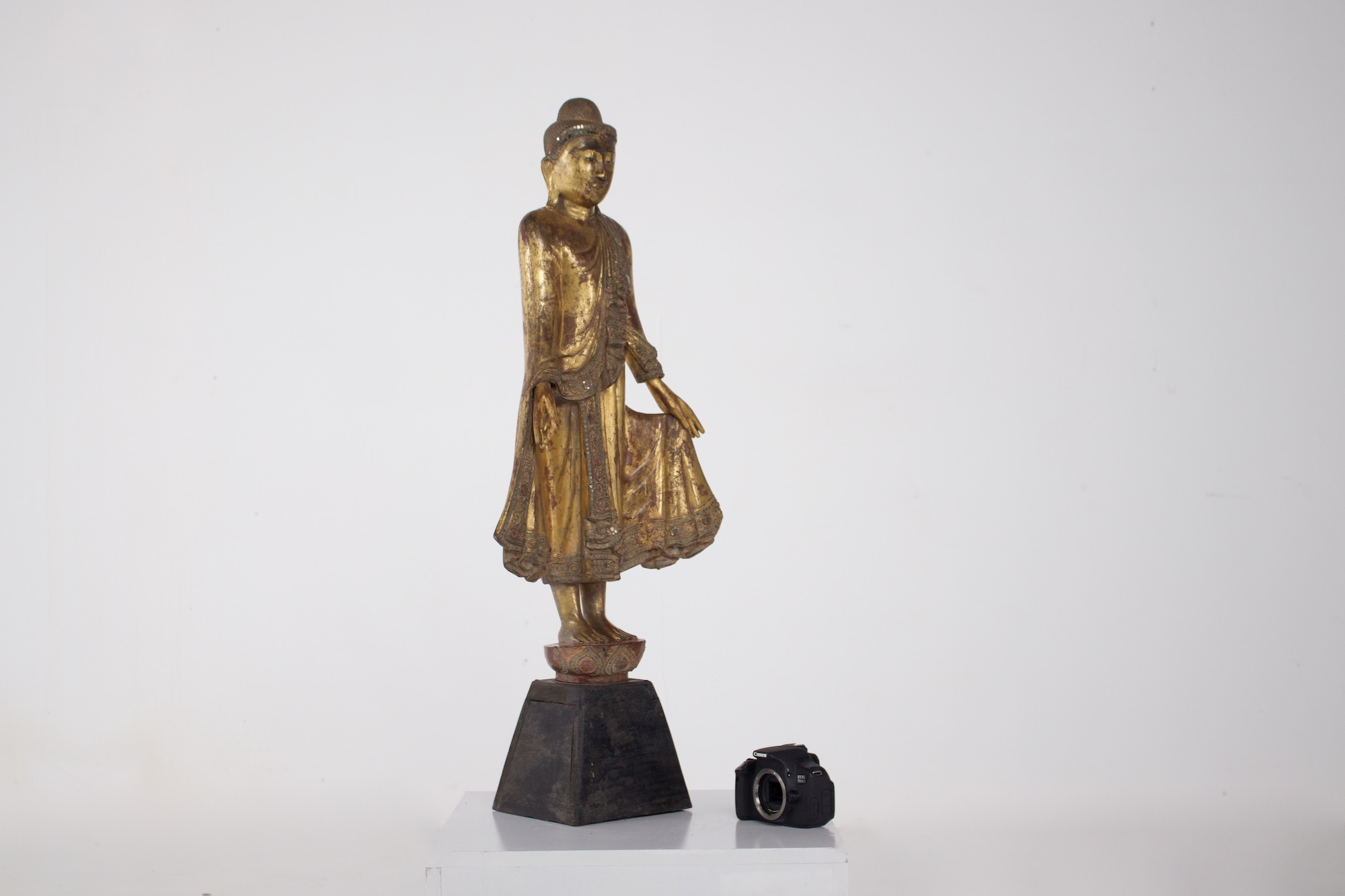 Statue ancienne de bouddha birman à côté d'un appareil photo