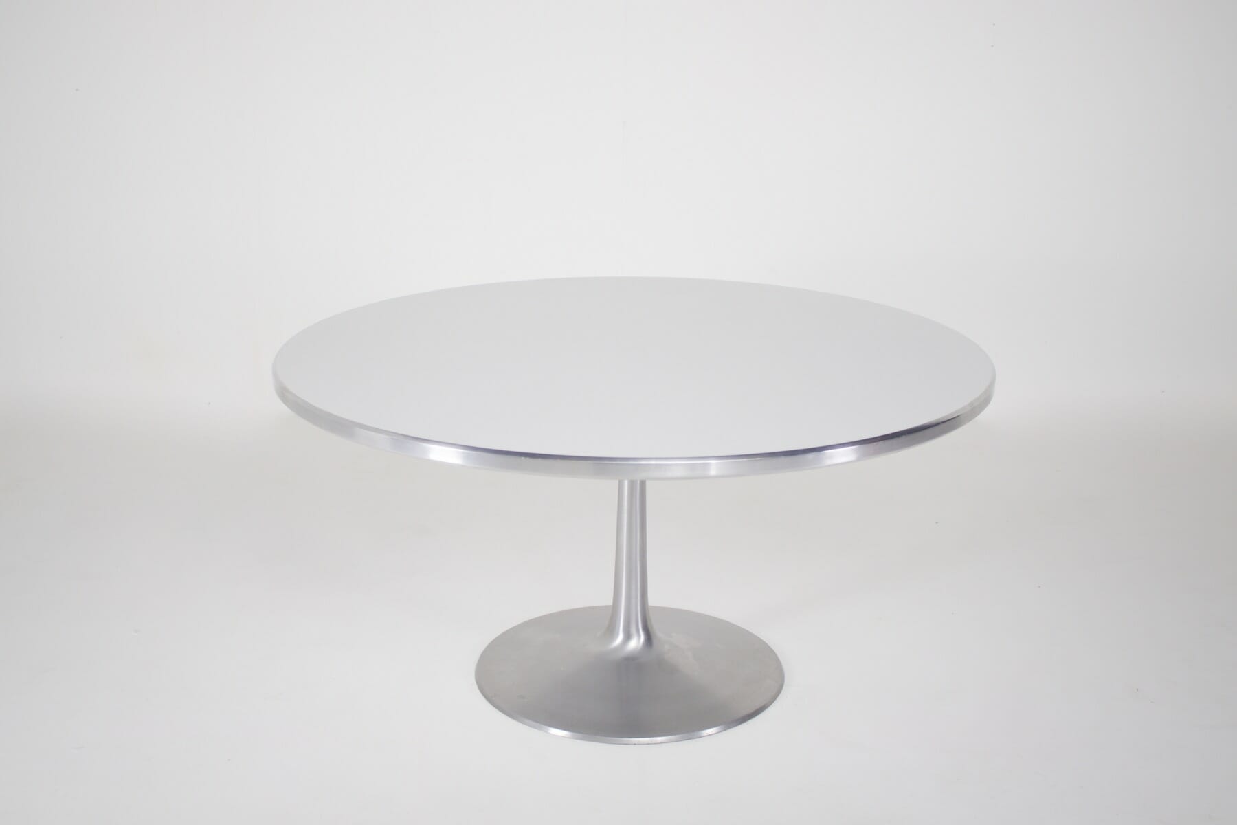 Table ronde blanche a pied central de forme tulipe vue de loin