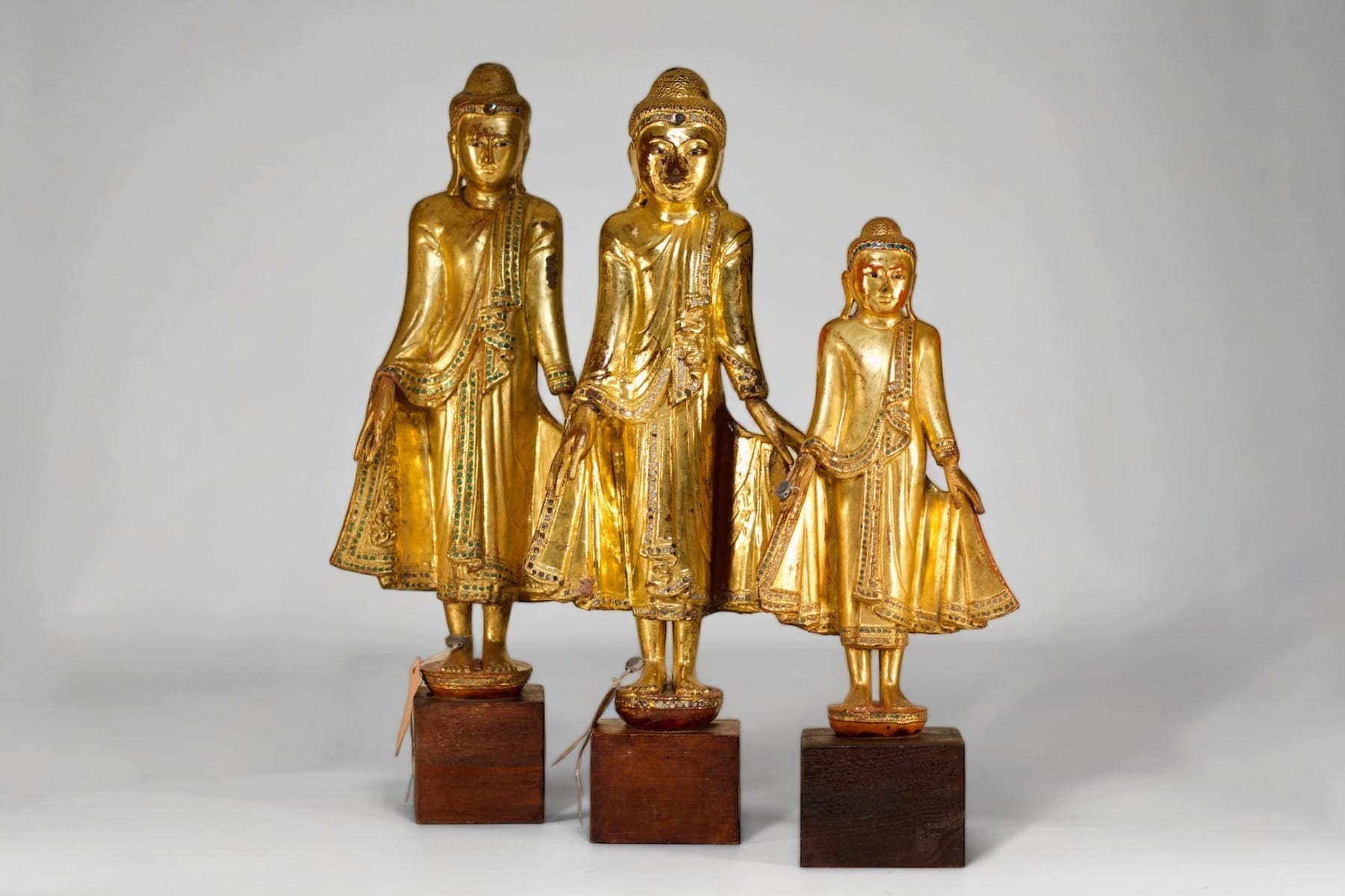 Suite de trois bouddhas anciens en bois doré de Birmanie