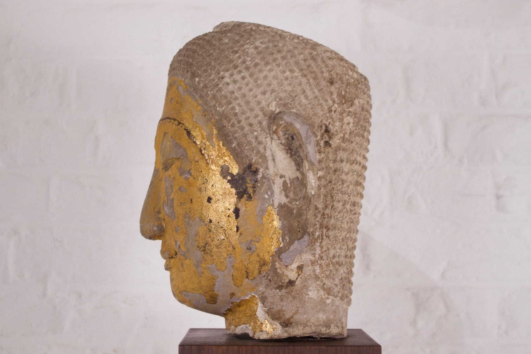 Profil droit d'une tête en pierre dorée Ayutthaya de la collection Claude de Marteau