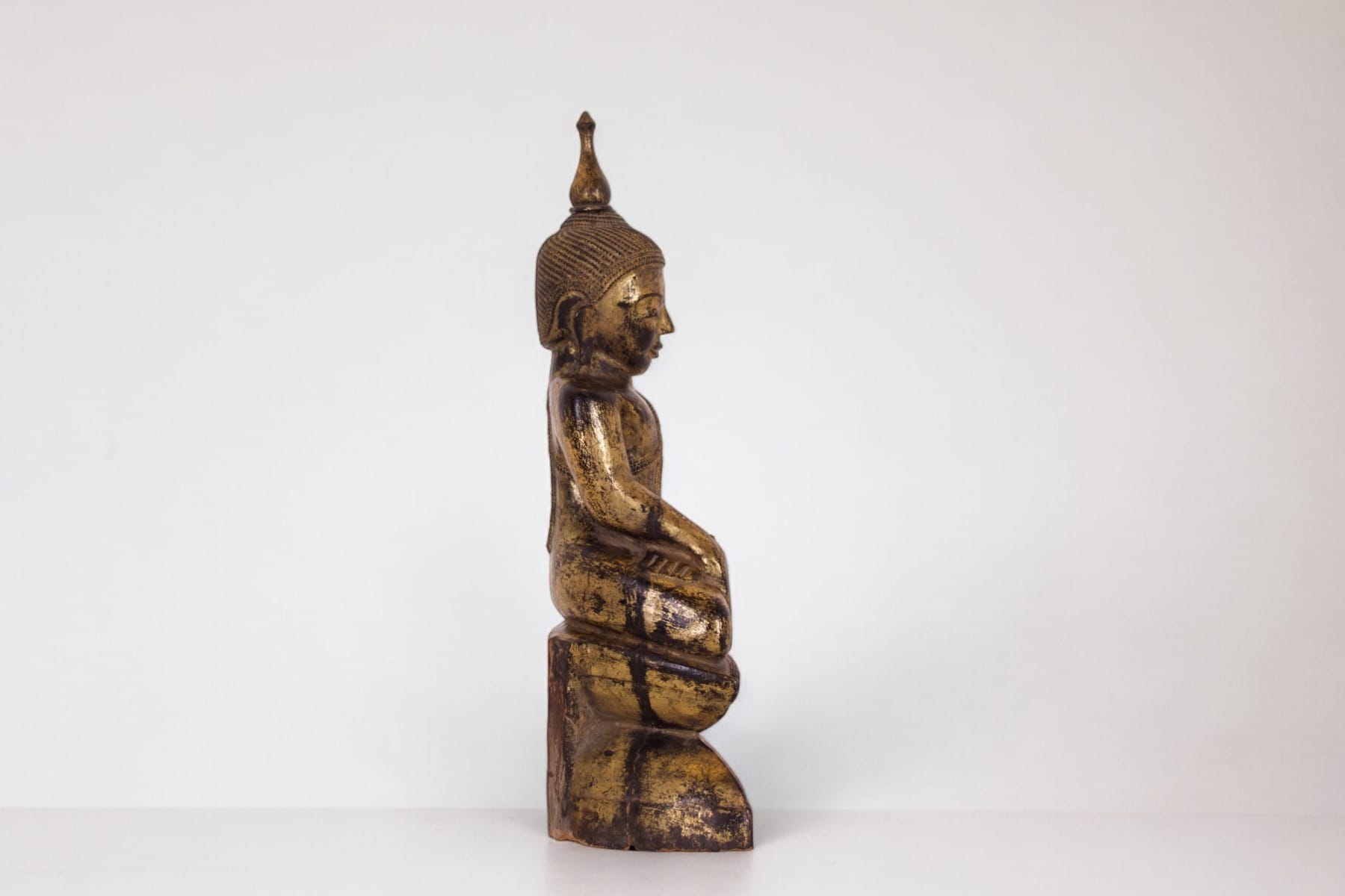 Le bouddha assis et de profil