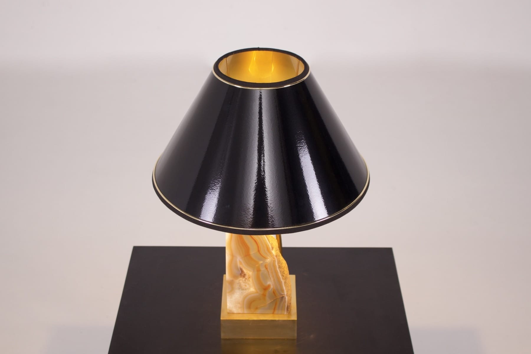 Lampe en laiton de Willy daro allumée avec une tranche d'agate en lulmière du jour