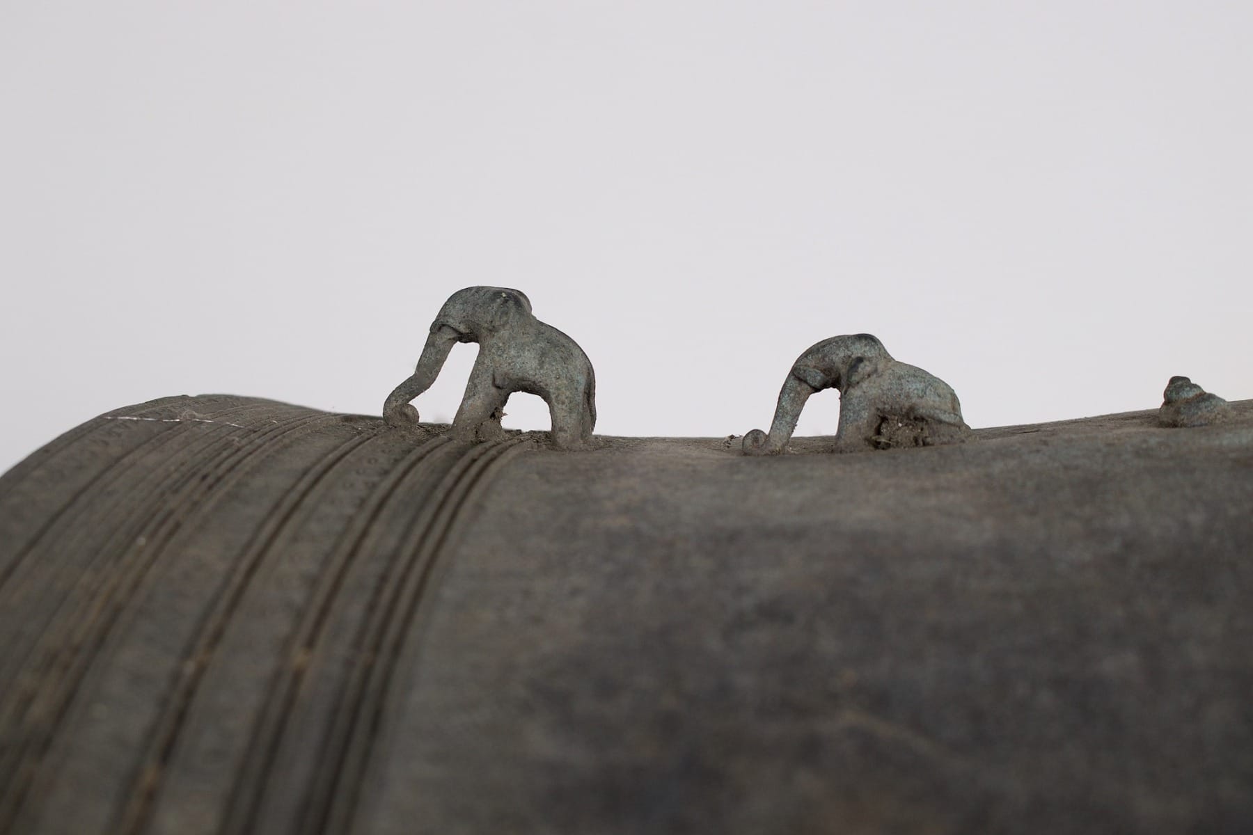 2 petits éléphants en bronze sur le côté du tambour