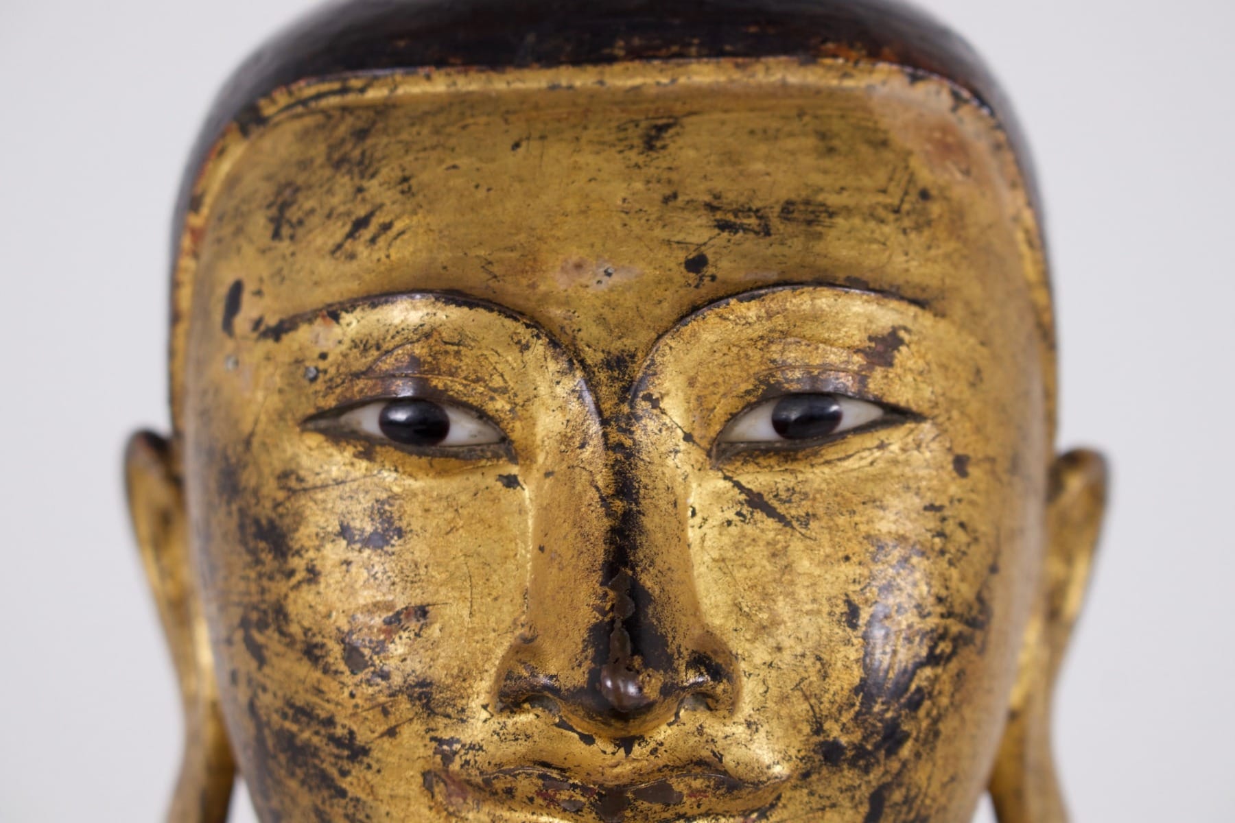 Gros plan sur le regard d'un ancien bronze birman d'un disciple ou donateur de Bouddha