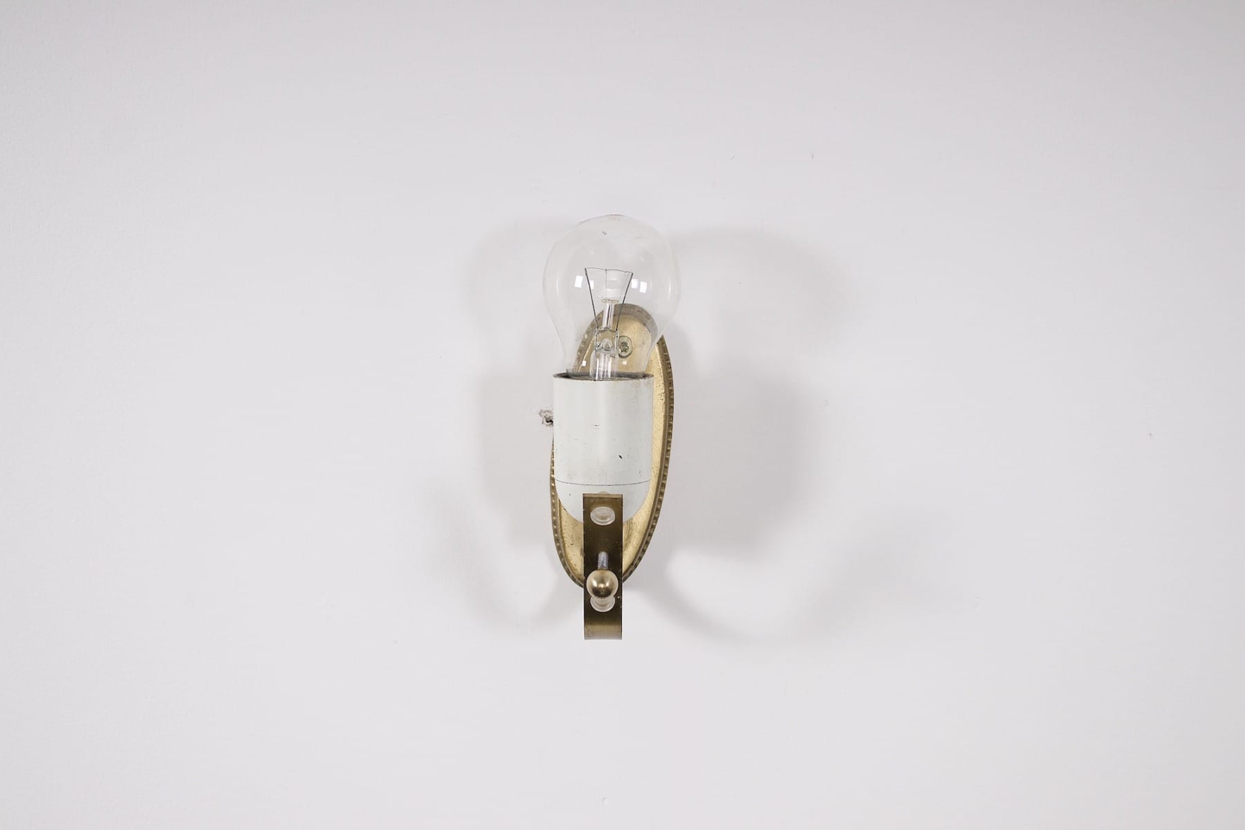 Le support en laiton et l'ampoule d'une des appliques