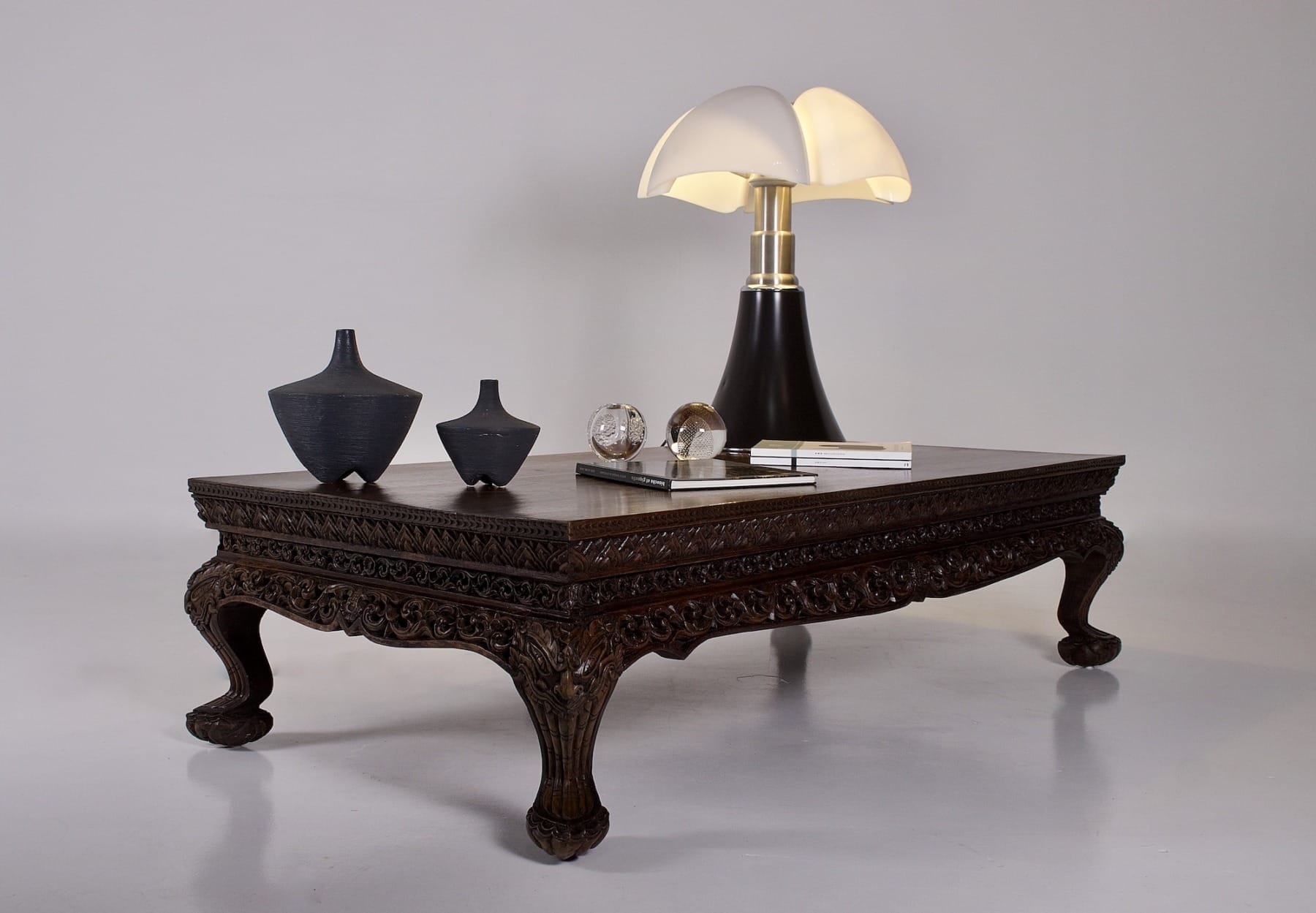 la table antique d'autel birman, une lampe Pipistrello, des vases, quelques magazines