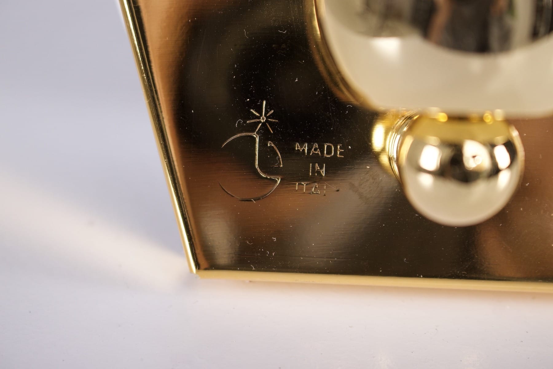 Le sigle de l'éditeur et Made in Italy gravés dans le socle en laiton