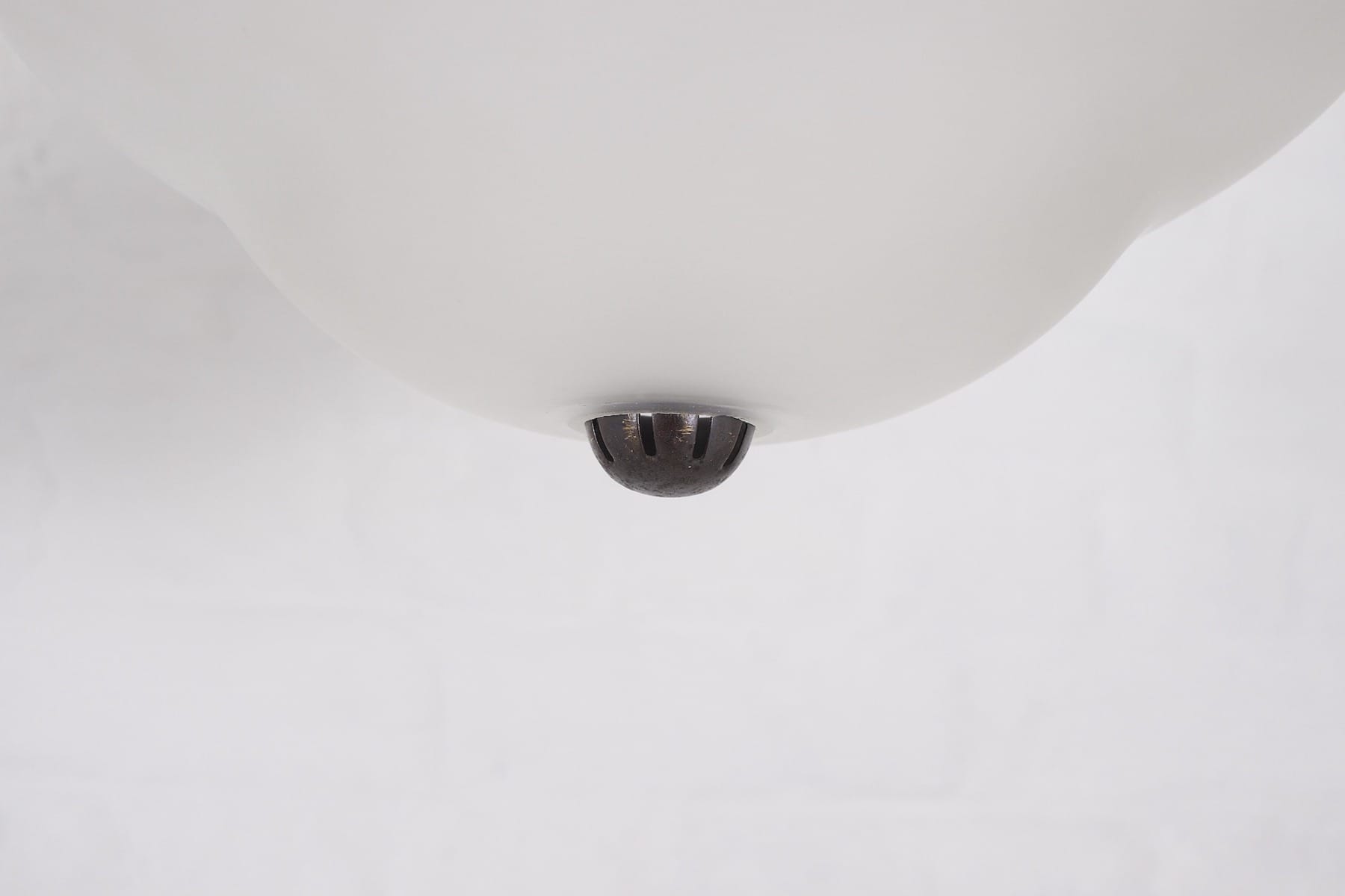 Détail du dessous d’une des lampes avec la petite capsule de finition.