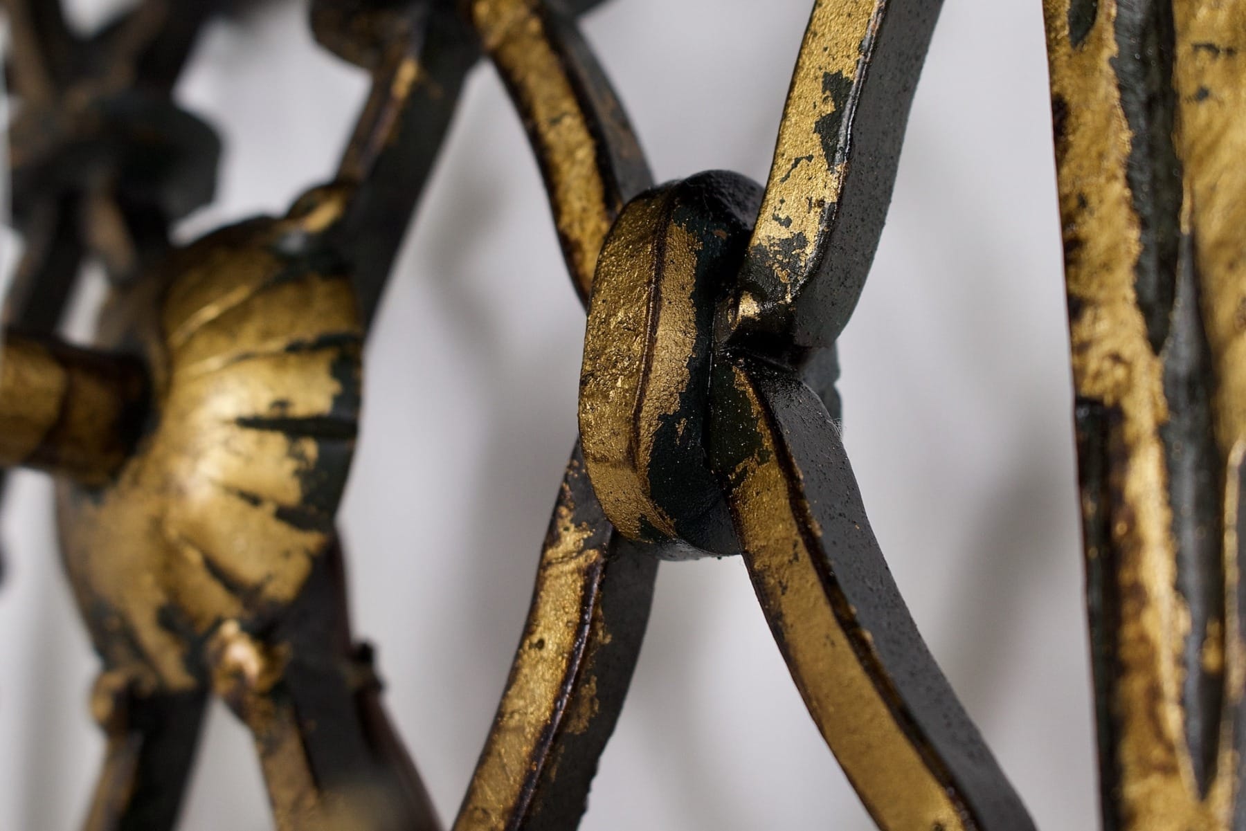 Un détail d'une des appliques en fer forgé doré