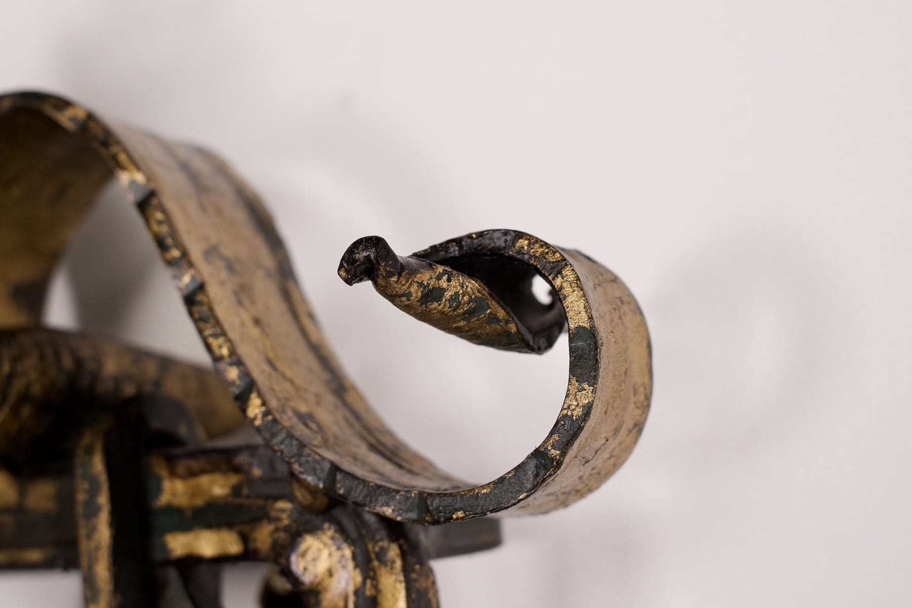 Un détail d'une des appliques en fer forgé doré