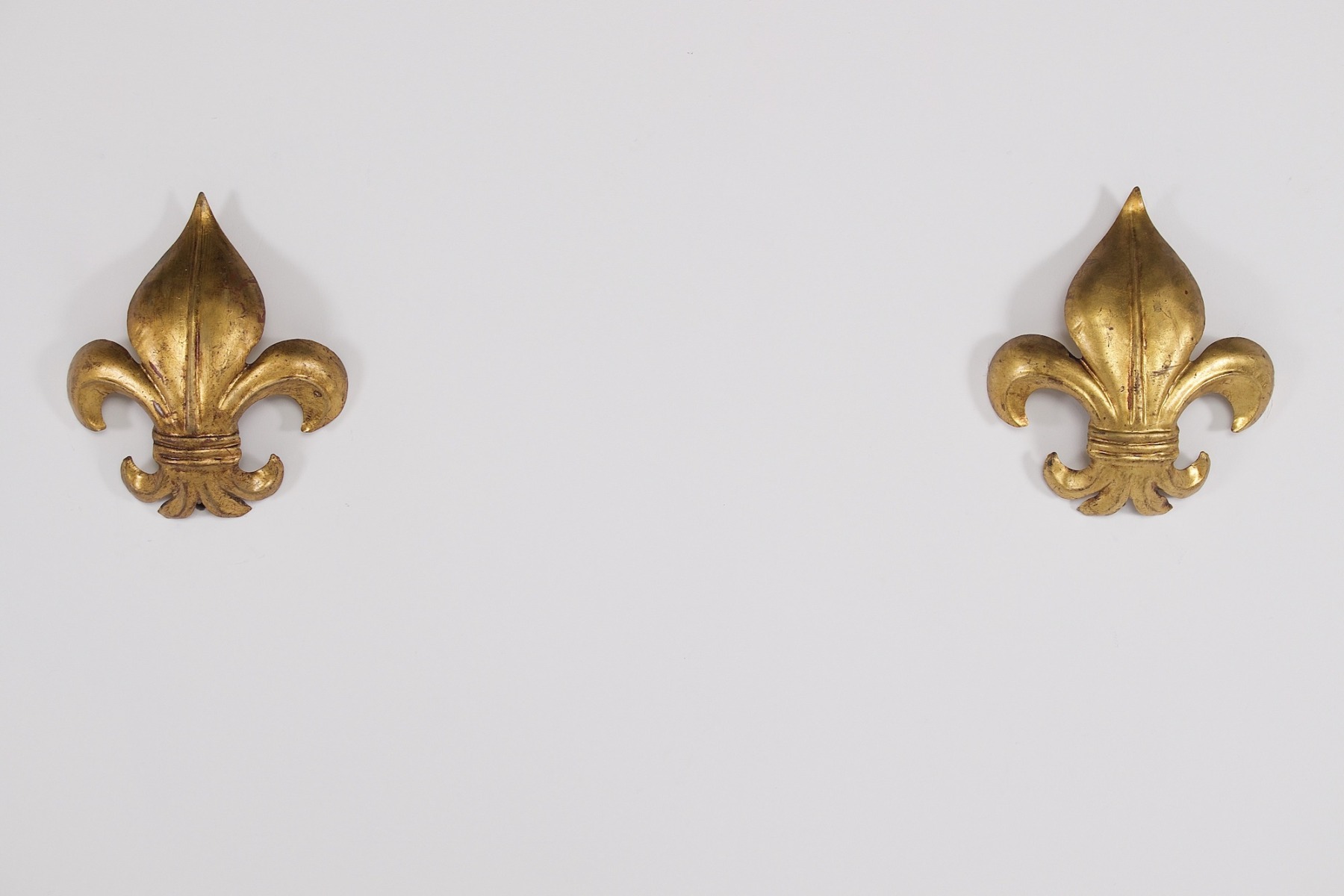 Une paire d'appliques en fer forgé doré. "Fleur de Lys" de face et éteinte