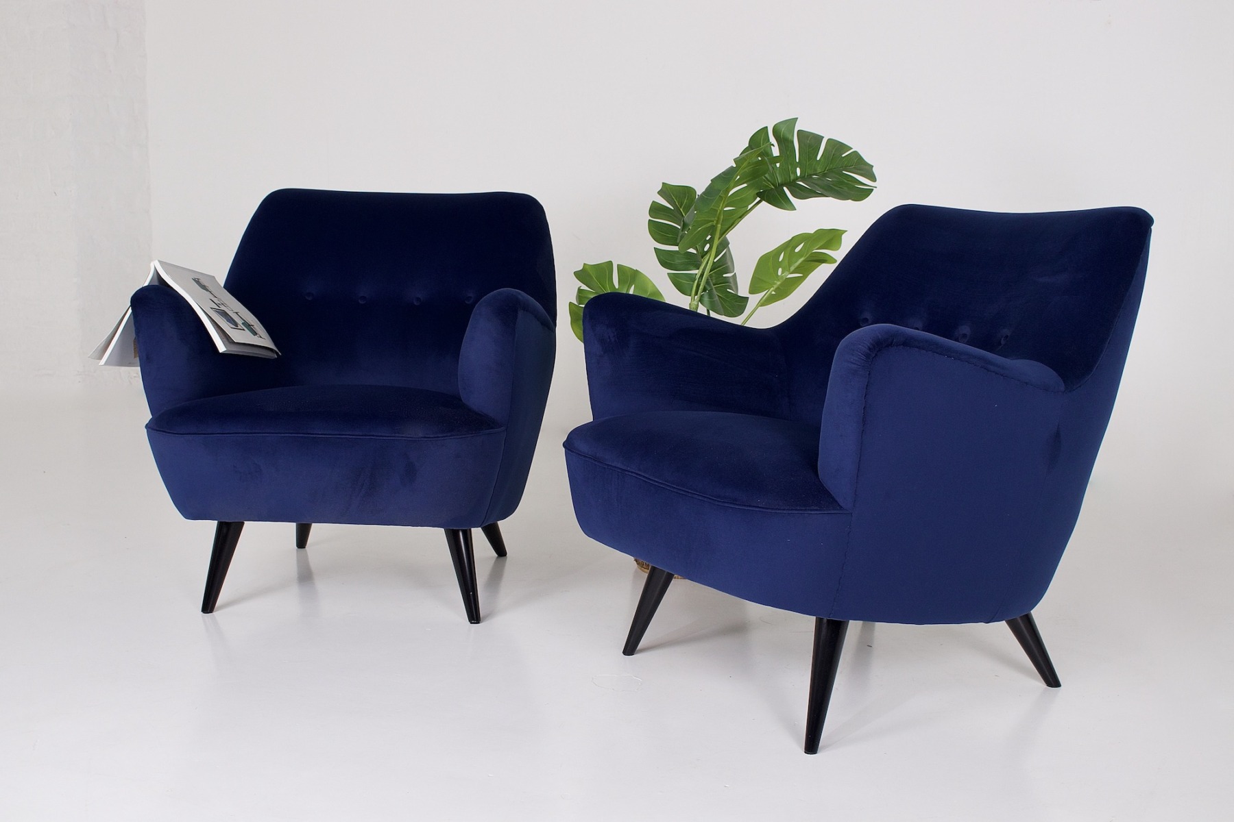 Paire de fauteuils Italiens en velours bleu, une plante, un magazine