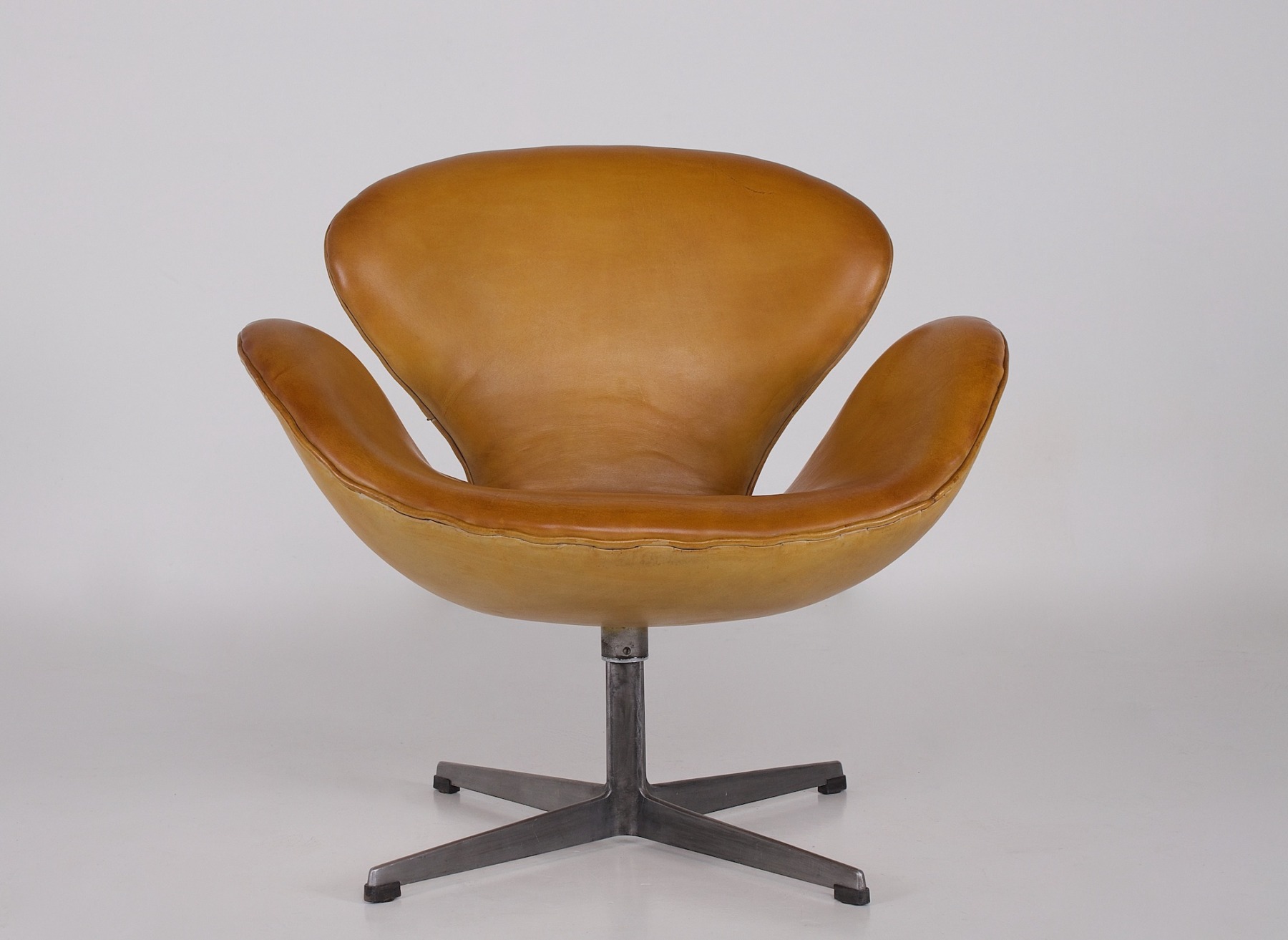 Swan chair Arne Jacobsen en cuir avec son pied métal en croix vu de face