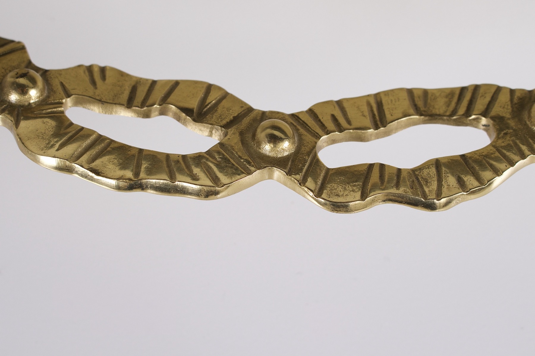 Gros plan sur un détail en laiton massif du cadre encerclant le miroir lumineux