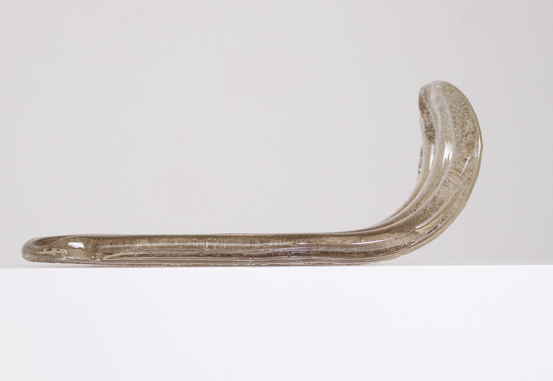 Un pétale de verre ambré, détaché de la suspension, une idée de l'épaisseur du verre