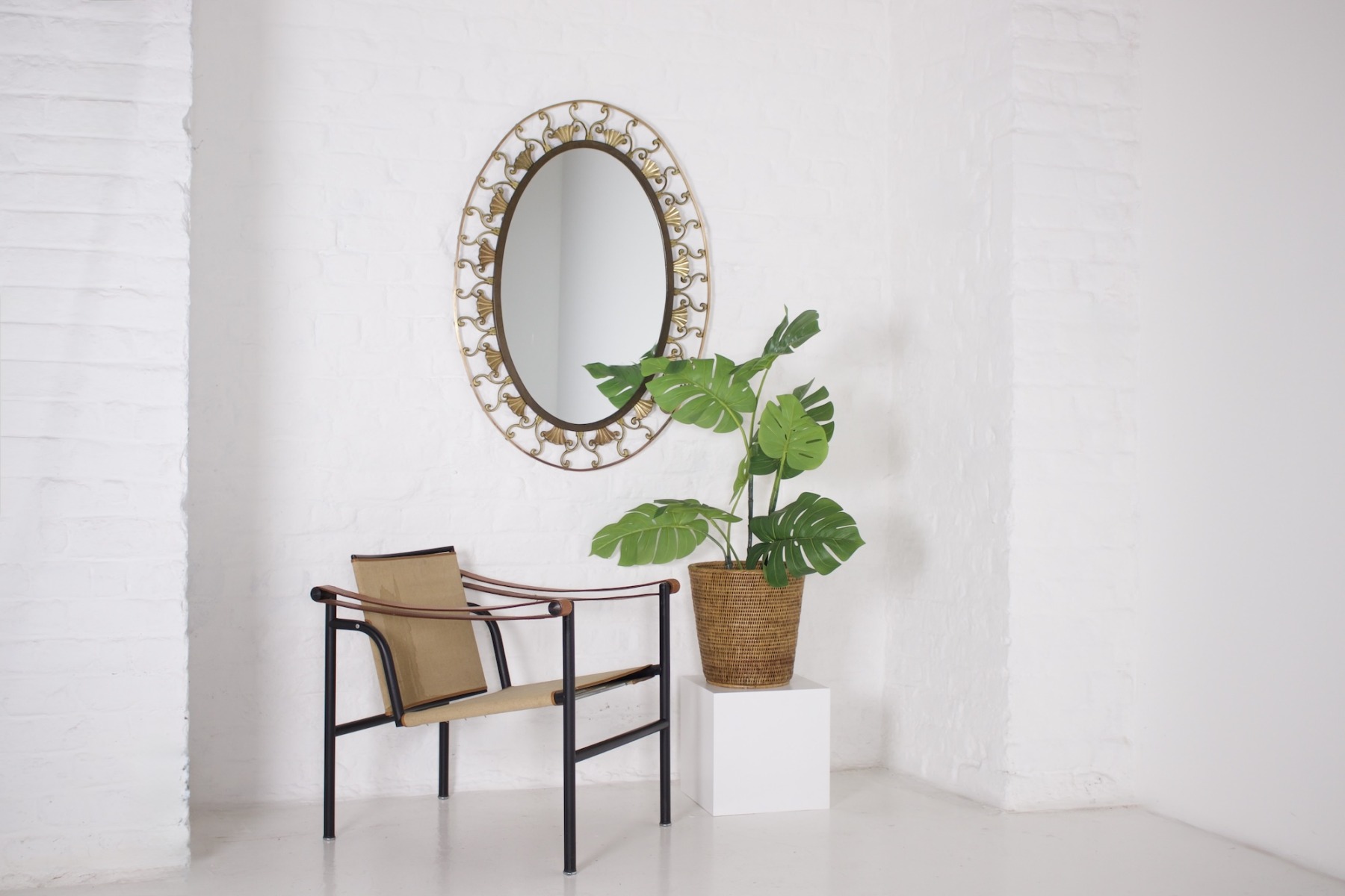 Miroir Art déco pendu au mur avec fauteuil Le Corbusier et plante verte