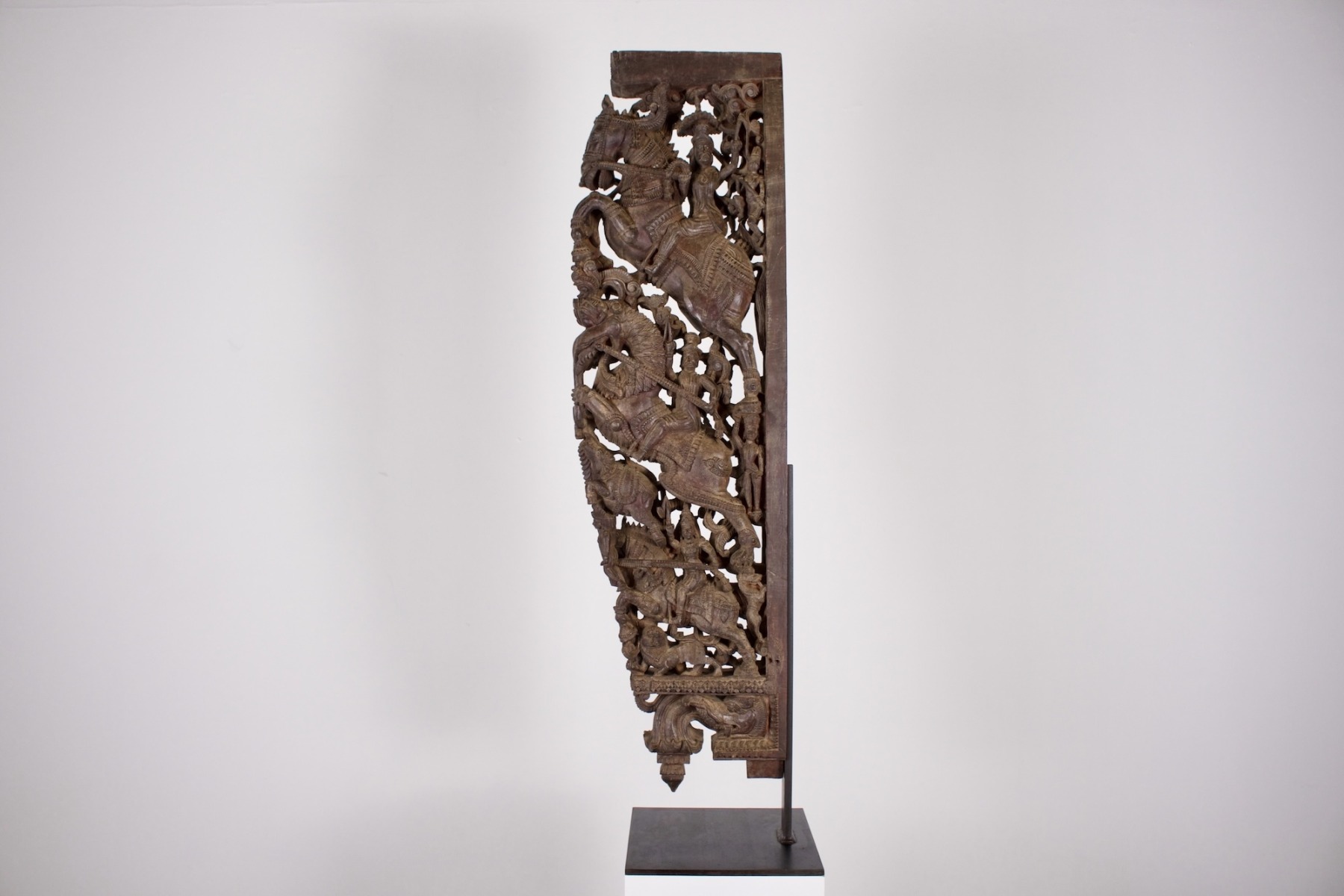 Une grande console indienne en bois sculpté avec cavaliers et yali montée sur socle