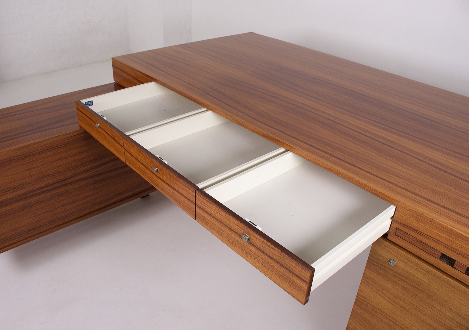 View of the cleanliness of the drawers opening in the top of the vintage desk from the 1960s or 1970s