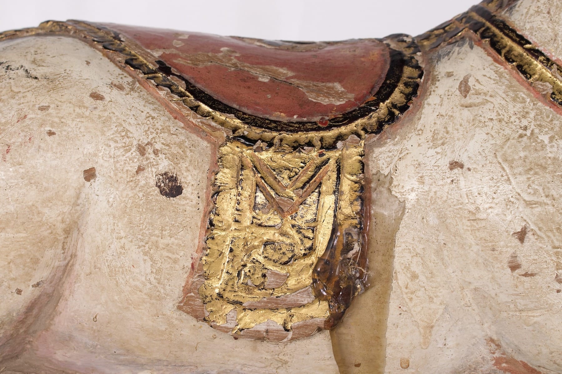 Selle décorée sur une sculpture de chèvre sacrée en bois