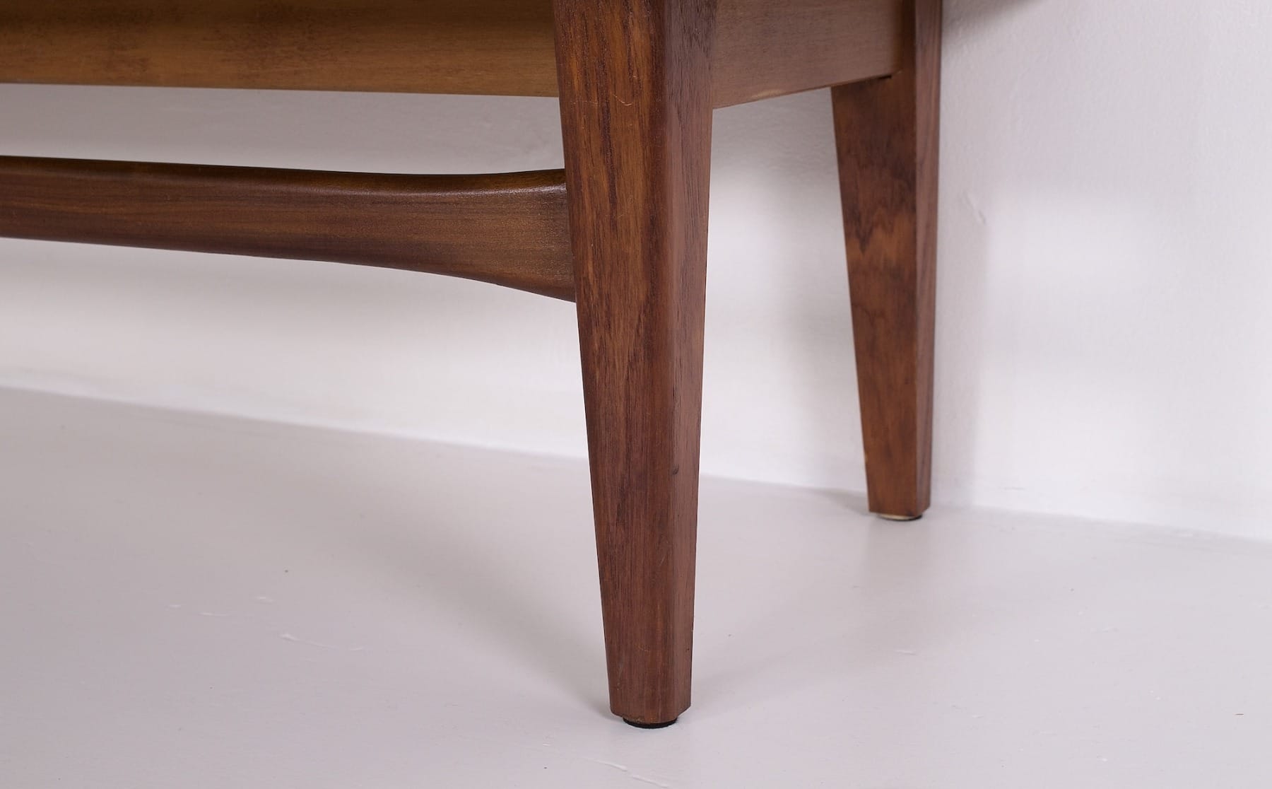 Detail of the leg assembly and their stretcher on a vintage Scandinavian sideboard