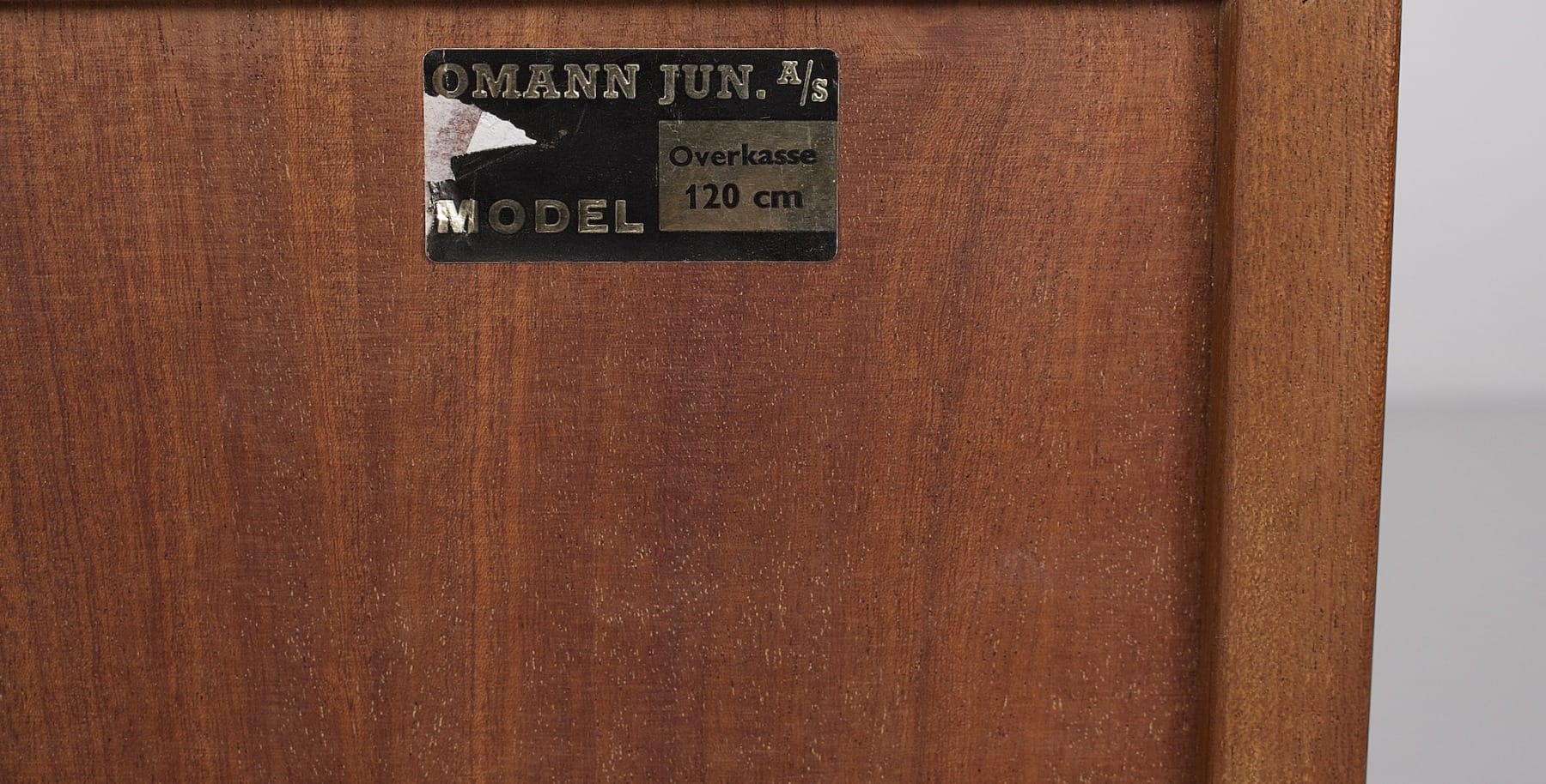 Etiquette de l'éditeur Omann Jun Denmark derrière un meuble de salon vintage