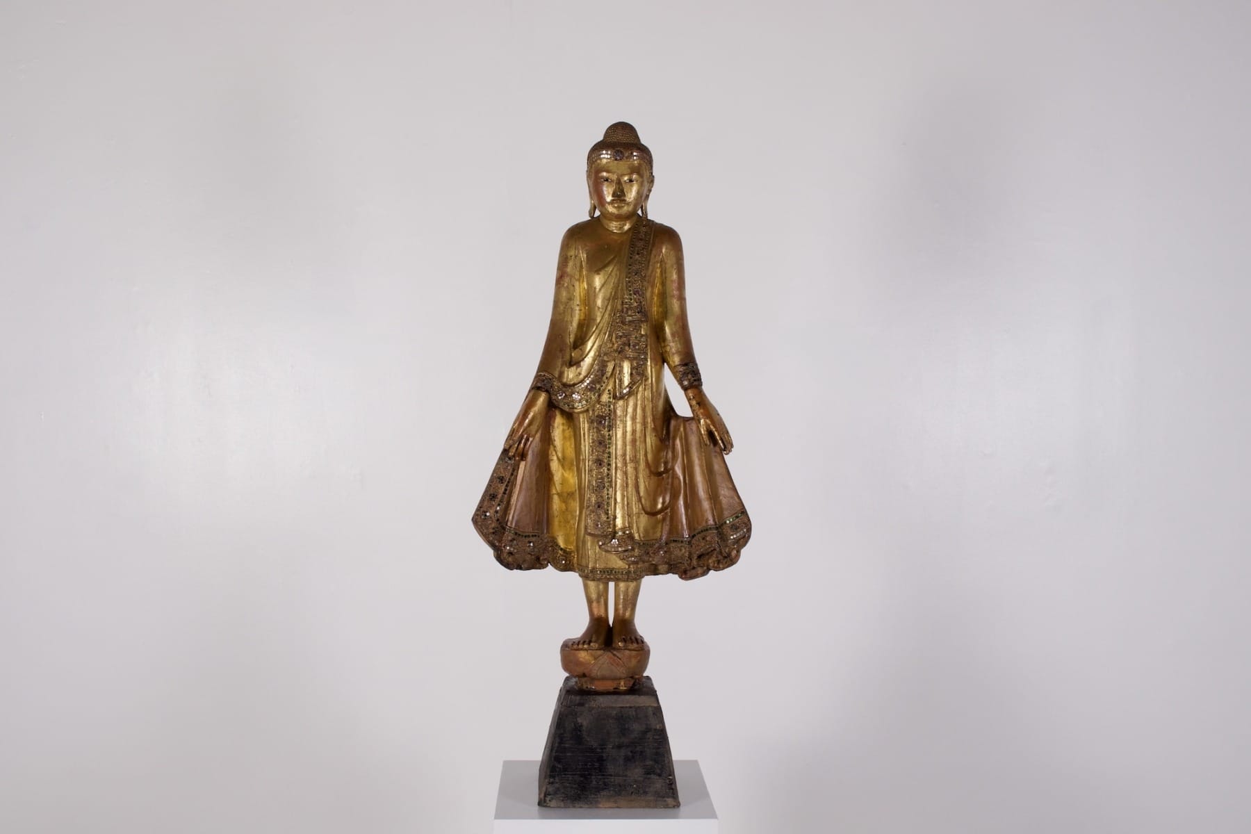 Une sculpture en bois doré du 19ème siècle de Shakyamuni debout tenant sa robe et le fruit du Myrobolan