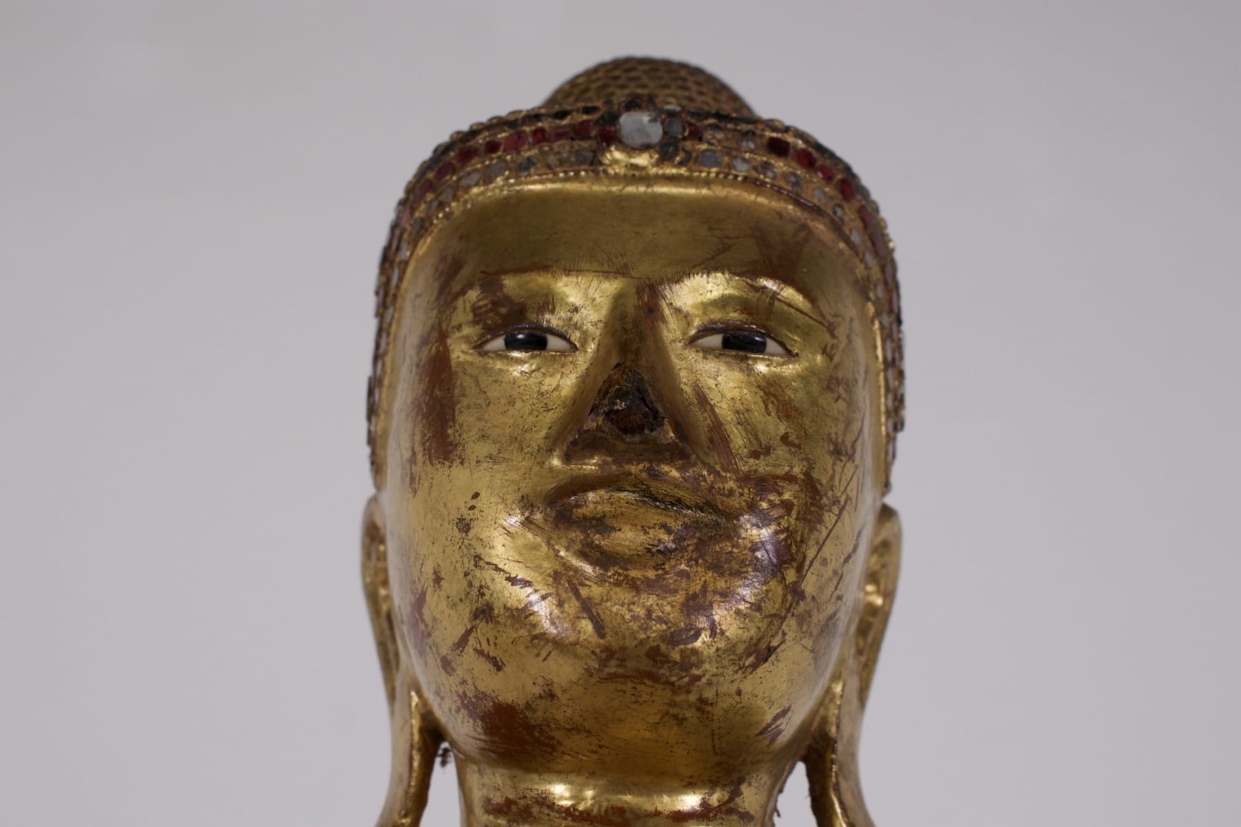 Burmese statue of the face and gaze of a wood sculpture representing the historical Buddha