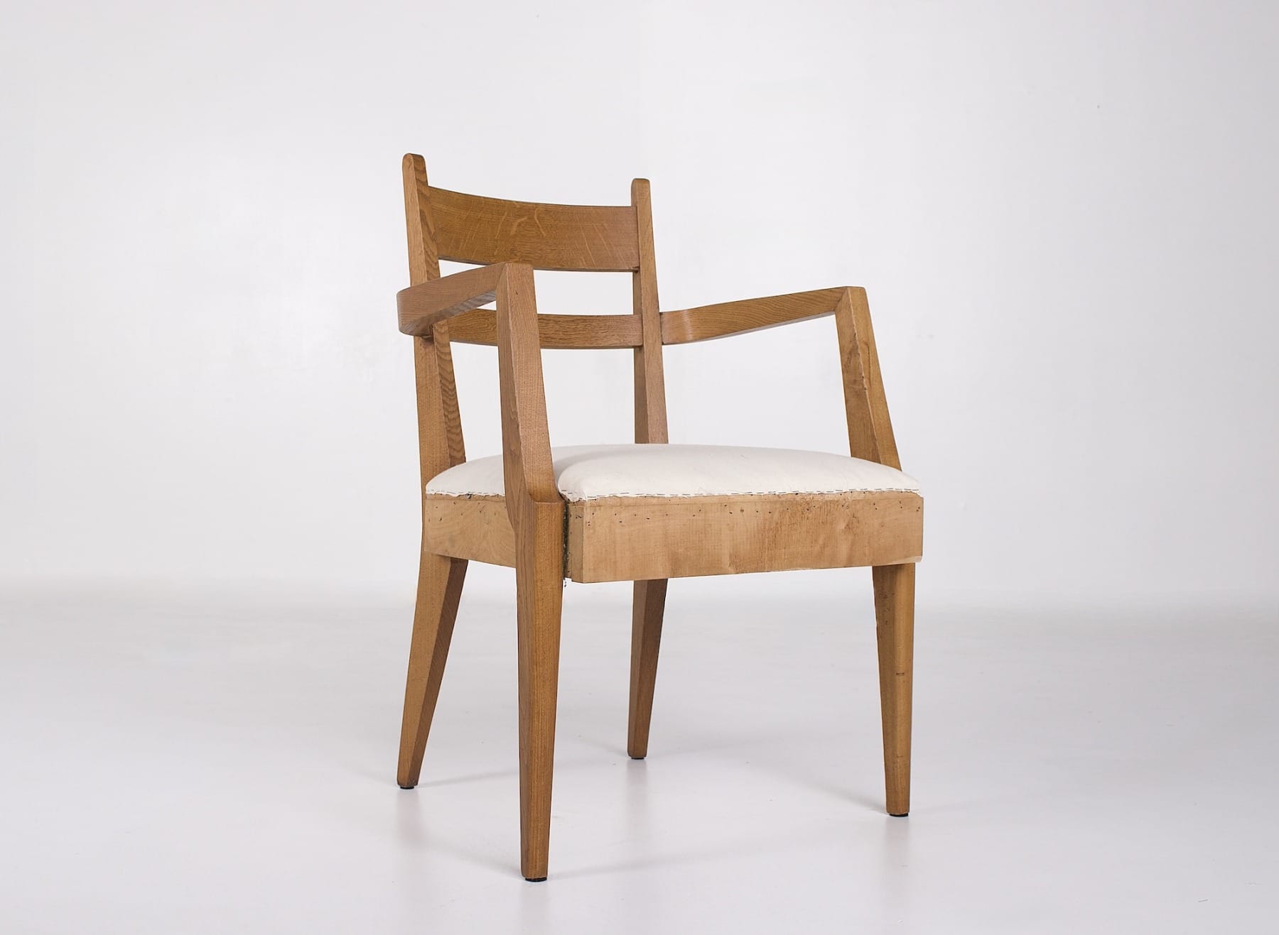 Un fauteuil en bois et tissus écrus de la période Reconstrcution française