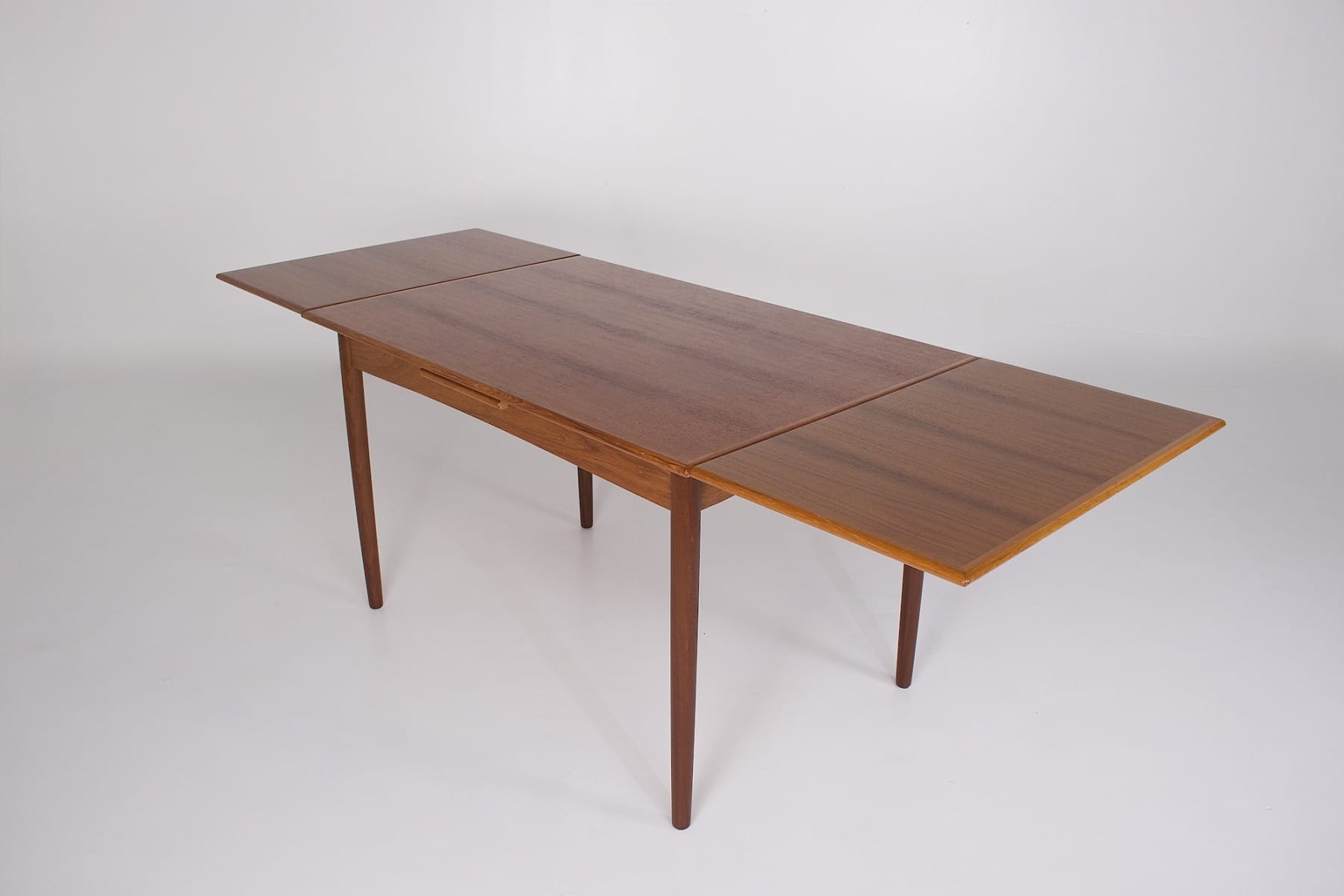 Vue du plateau allongé pour 6/8 personnes d'une table scandinave années 60 ou années 70 en teck