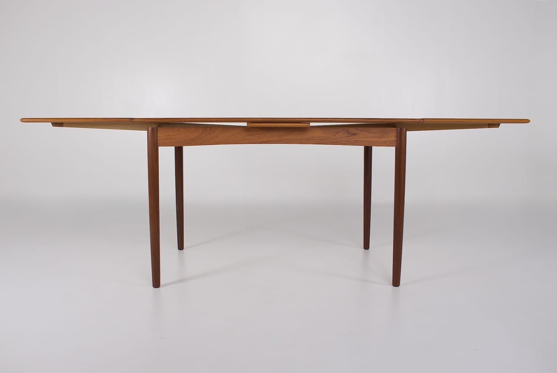 Vue de profil d'une table à manger danoise avec ses deux rallonges étirées